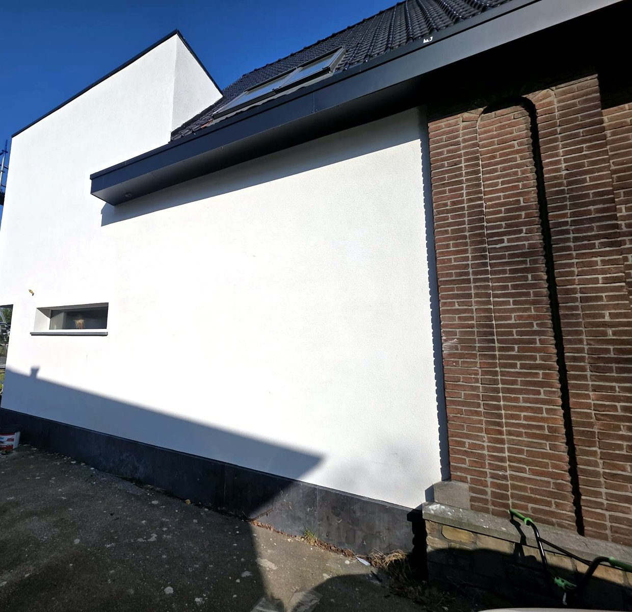 Extension contemporaine enduite avec toiture, réalisée par Belara Construct